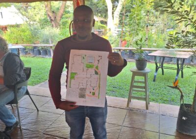 Findings Green Solutions outdoor landscape design plan presentation at a garden event.